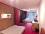 Zimmer mit Bett, Schrank, Schreibtisch und Sitzecke