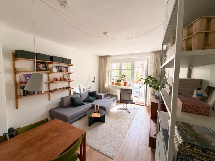 Wohnzimmer mit Couch und Zugang zum Balkon