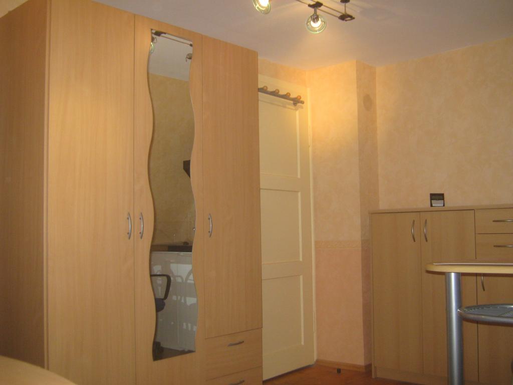 Habitación en WG Milbertshofen-Am Hart Wolfoltstr. - Kleiderschrank mit Spiegel, Kleiderstange, 5 Einlegeböden und 2 Schubladen, rechts davon die Zimmertüre mit Garderobenleiste