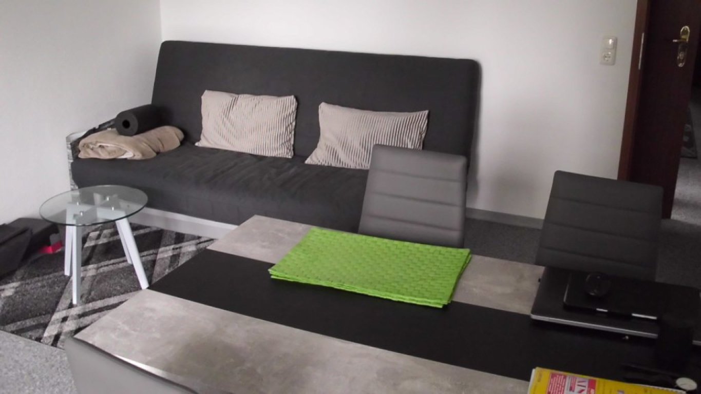 WG-Zimmer Titz Meerhofstraße 1 B - Wohnzimmer Couch und Esstisch