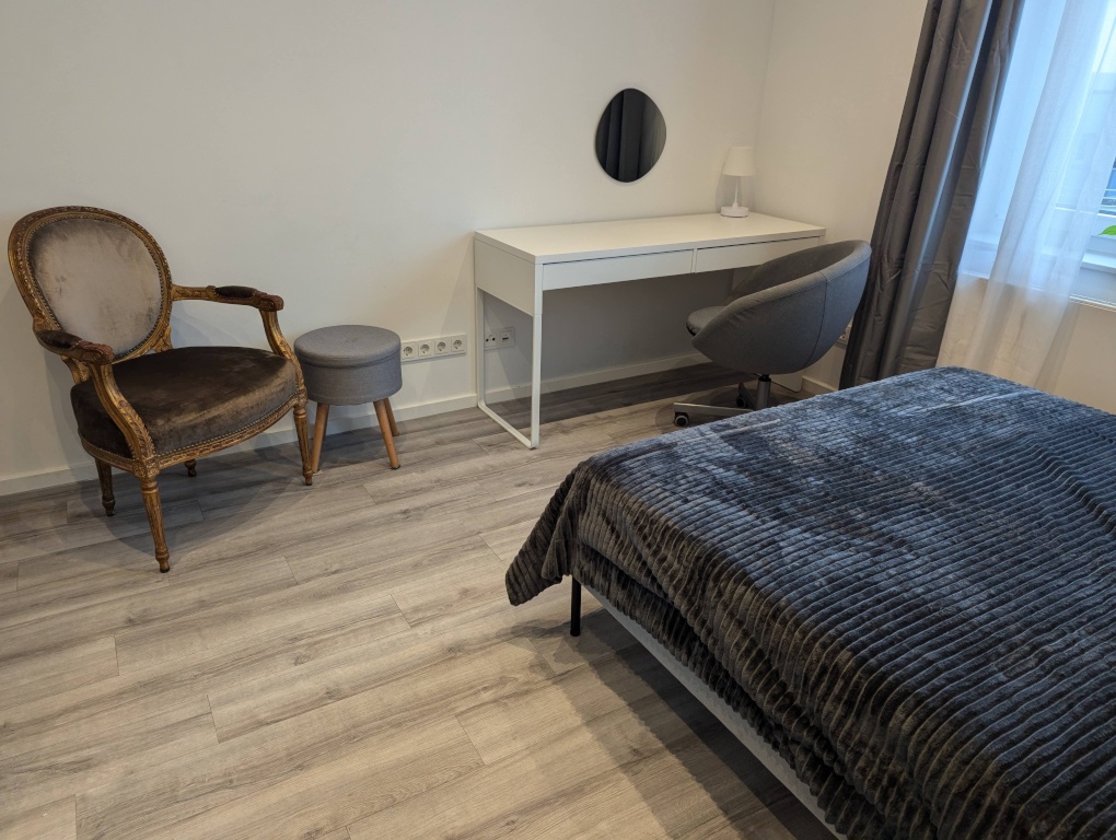 WG-Zimmer Innenstadt An der Staufenmauer 11 - Blick vom 140*200cm Doppelbett auf Lesestuhl und Arbeitstisch
