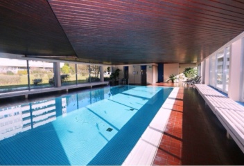 Ad image: Fully furnished apartment with separate studio, indoor pool, sauna, and tennis court by the forest.