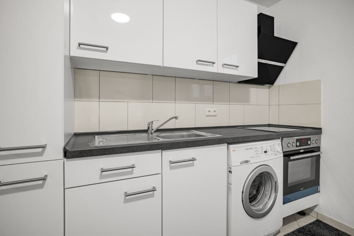 WG-Zimmer Garching Bergasternweg 22 - Moderne Gemeinschaftsküche mit Herd, Backofen, Waschmaschine und viel Stauraum