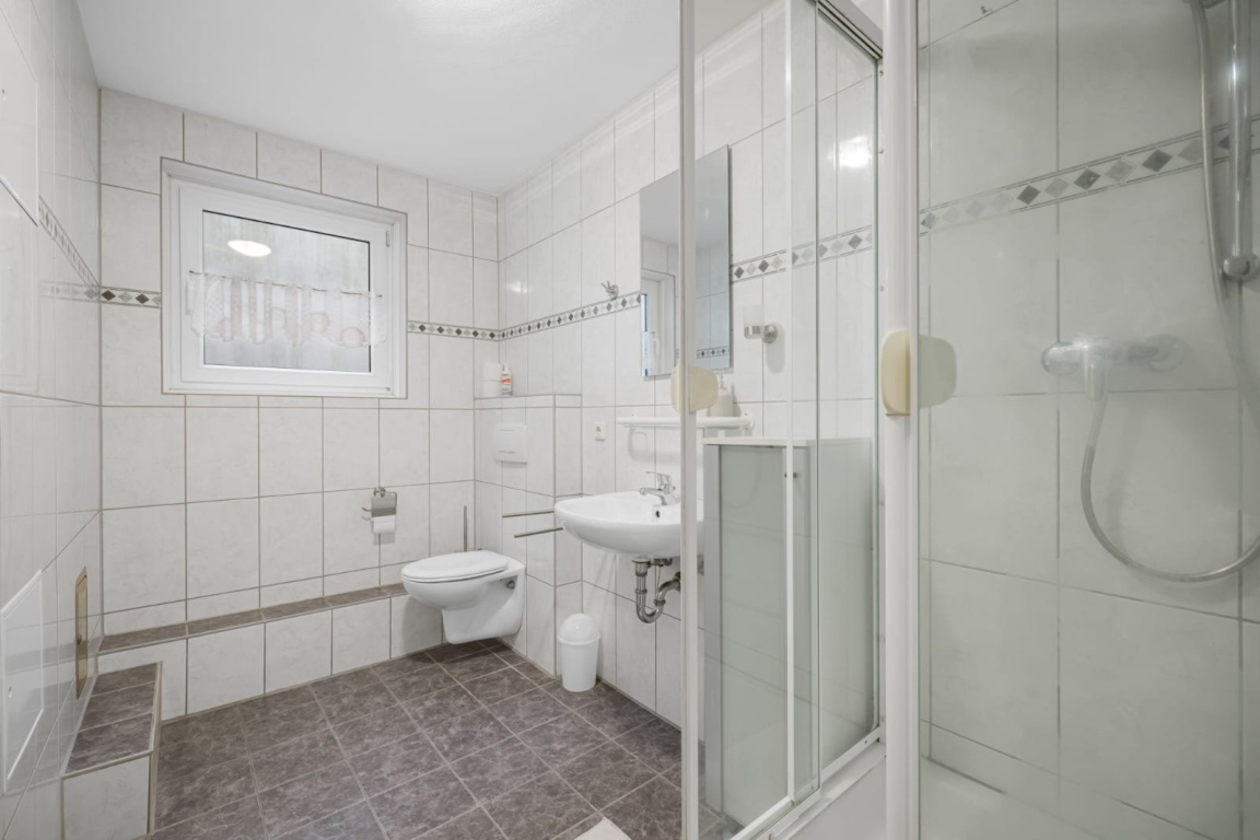 WG-Zimmer Garching Bergasternweg 22 - Großes Gemeinschaftsbad mit Dusche, WC, Waschbecken und Fenster – sehr gepflegt