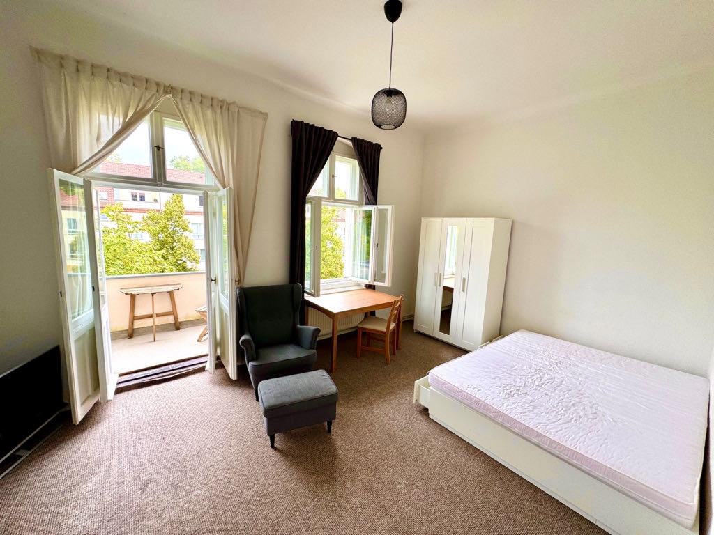 Apartamento Karlshorst Stolzenfelsstr. - Balkonzimmer in den Garten mit neuem Bett, Sessel, Spiegelschrank und Tisch.