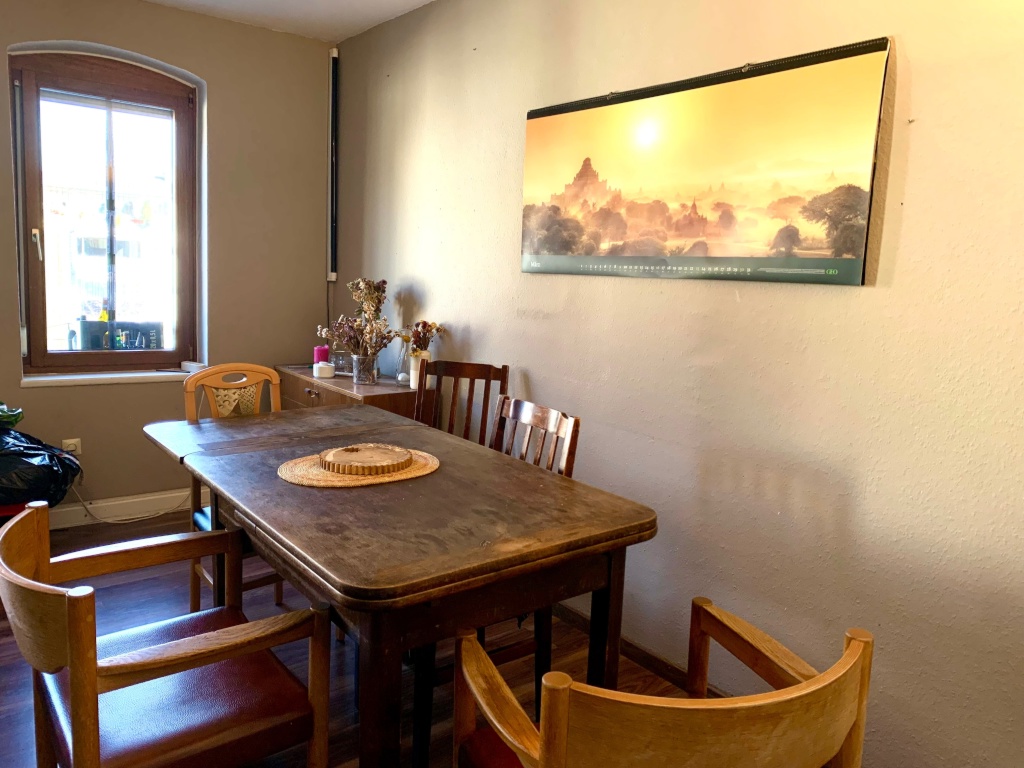 WG-Zimmer Bad Cannstatt Wildunger Straße 39 - Wohnzimmer mit Esstisch, Fenster in den Hinterhof und einem großen Jahreszeitenkalender