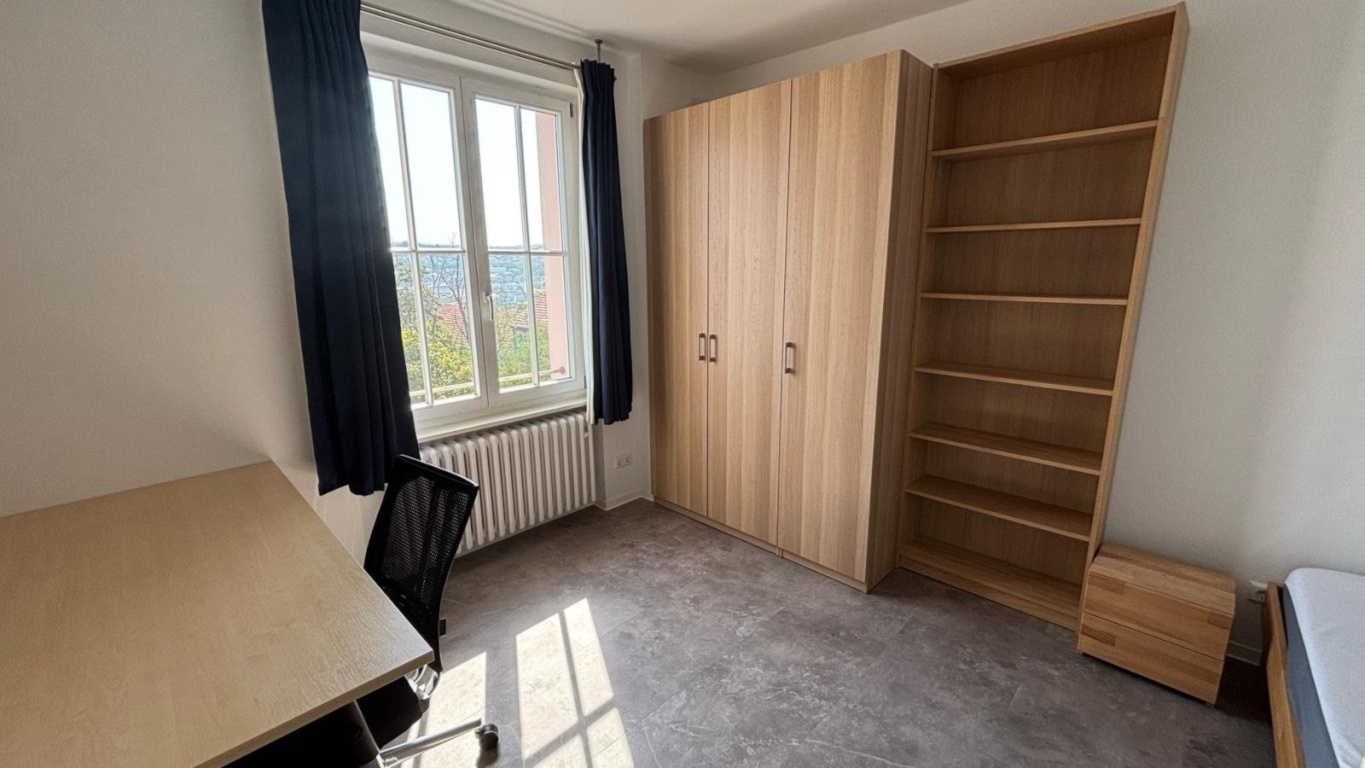 Habitación en WG Nord Birkenwaldstrasse 40 - Zimmer mit Kleiderschrank und Regal – hell, möbliert, mit Blick ins Grüne.