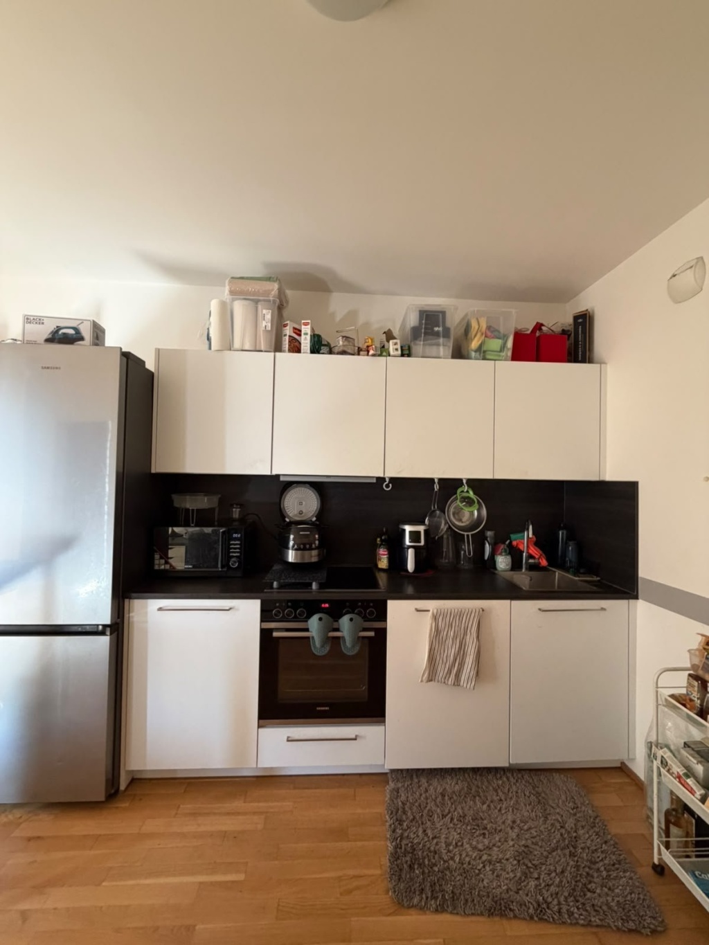 Wohnung Schöneberg Gotenstraße - Einbauküche mit Kochfeld, Backofen und Spüle; links die große Kühl-Gefrier-Kombination